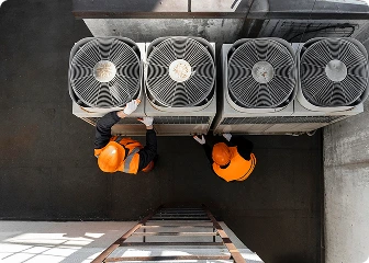 Two HVAC professionals performing maintenance