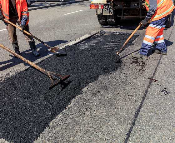 Men working on professional asphalt repair on a roadway