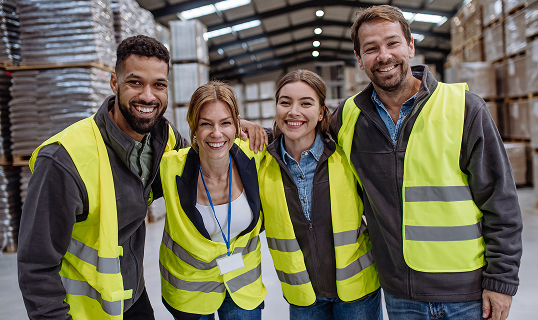 Smiling maintenance workers posing in a warehouse
