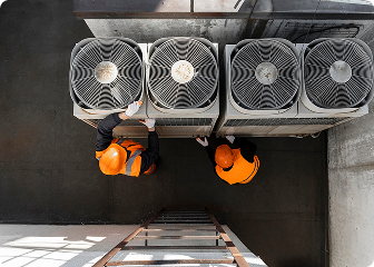 professional HVAC service workers performing maintenance on air conditioners