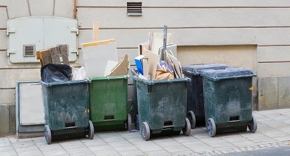 Trash bins on the street overflowing beofre bulk refuse services
