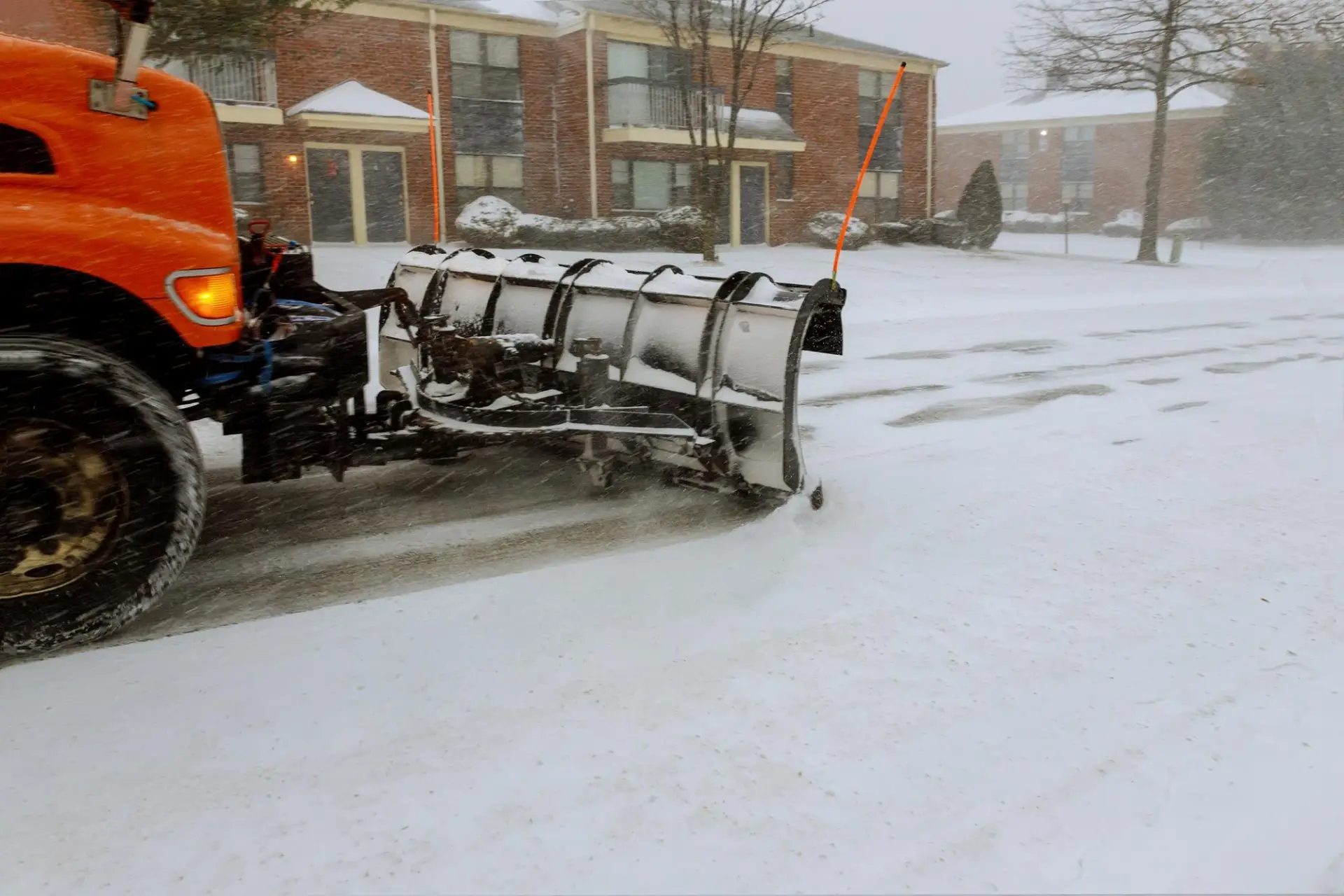 Commercial snow plow truck clearing a Raleigh, NC commercial property during a winter storm