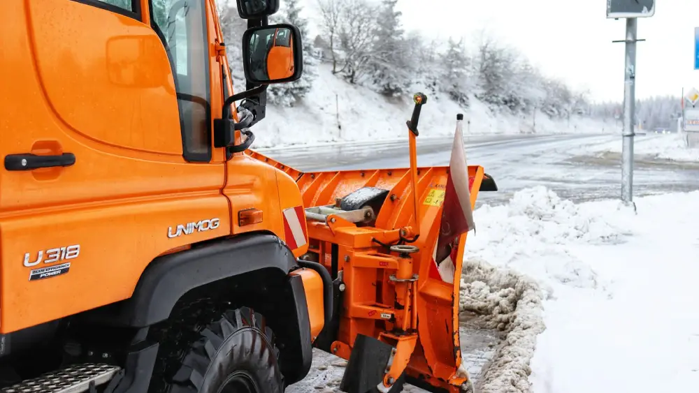 Commercial snow plow clearing a road in Raleigh, NC